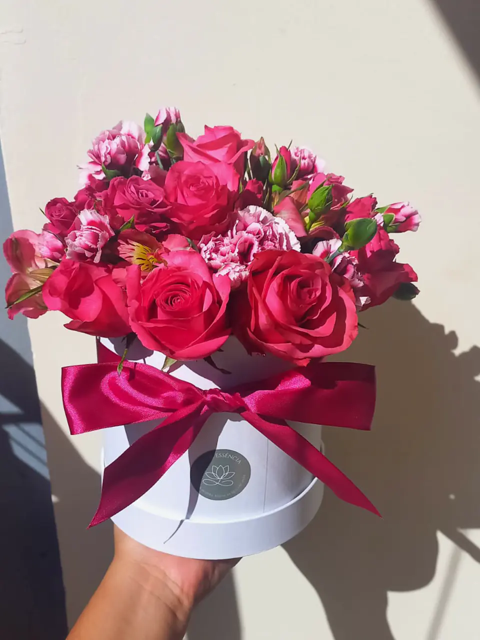 Box de flores em tons de pink com rosas e cravos e laço de cetim vinho