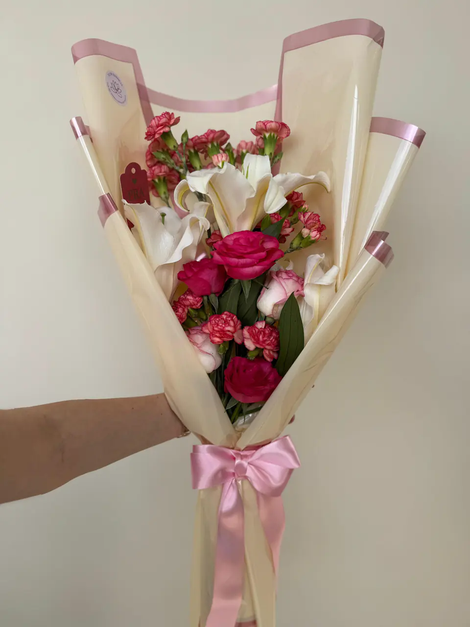 Buquê em tons de rosa com astromélias e cravos em papel creme