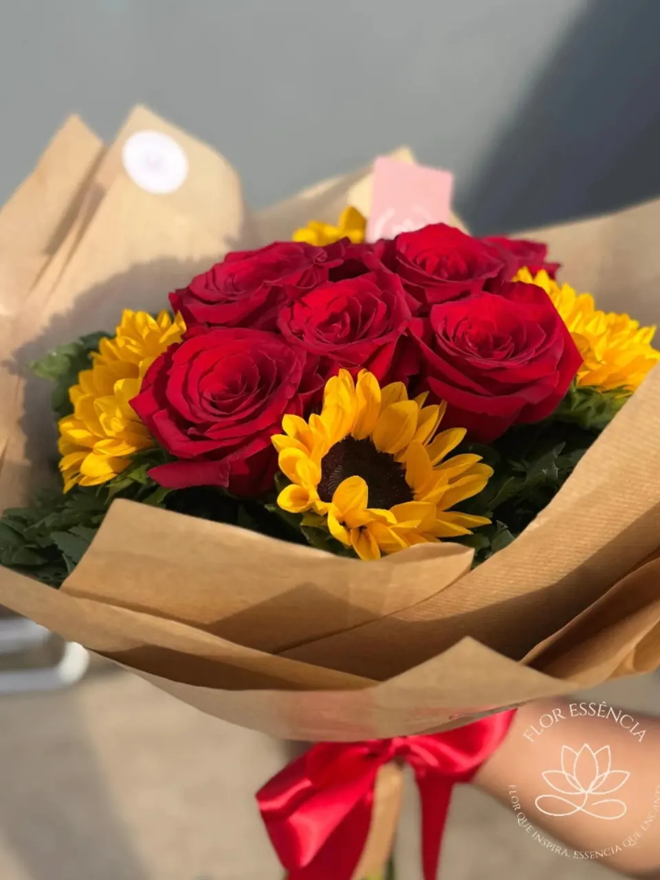 Buquê de girassóis com rosas vermelhas em papel kraft e laço vermelho